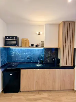 a kitchen with a black counter top and wooden cabinets at Apartment in Nueva Cba meters from Buen Pastor in Cordoba