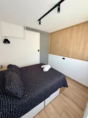 a bedroom with a bed with a black comforter at Apartment in Nueva Cba meters from Buen Pastor in Cordoba