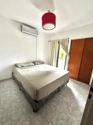 a bedroom with a large bed with a red light at alojamiento centrico vcp in Villa Carlos Paz