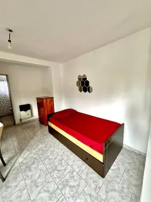 a bedroom with a bed with a red blanket at alojamiento centrico vcp in Villa Carlos Paz