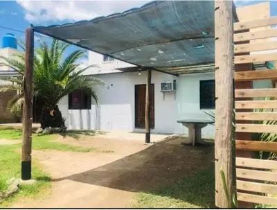 a picnic table under a pergola in front of a house at Turismo CarlosPaz in Villa Carlos Paz