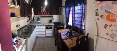 a kitchen with a table and a sink and a counter at Turismo CarlosPaz in Villa Carlos Paz