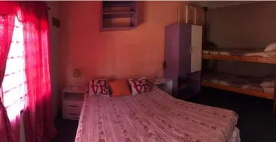 a bedroom with a large bed with a pink comforter at Turismo CarlosPaz in Villa Carlos Paz