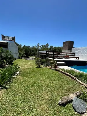 a backyard with a pool and a yard with grass and a practition at Los Jazmines in Alta Gracia