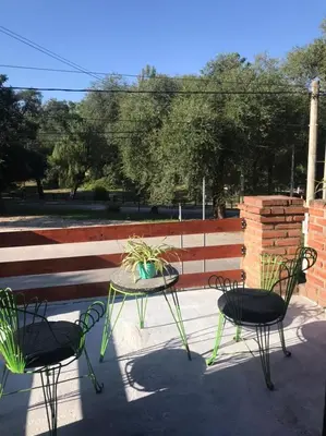 a patio with two chairs and a table with a potted plant at Los Jazmines in Alta Gracia