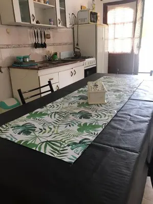 a kitchen with a table with a green and white rug at Los Jazmines in Alta Gracia
