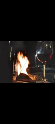 a glass of wine and a fire in a fireplace at Campo Dulce Esperanza in Bialet Massé