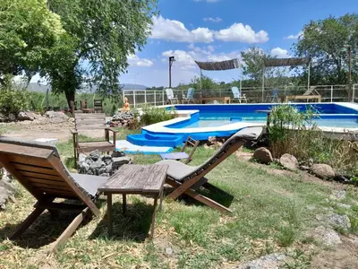a pool with two chairs and a bench in a yard at Campo Dulce Esperanza in Bialet Massé
