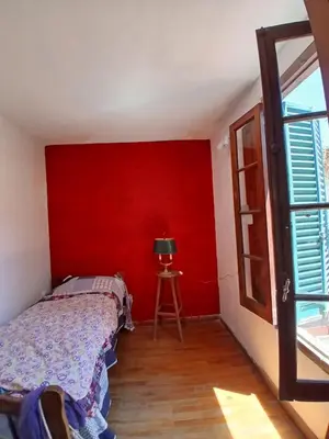 a bedroom with a red wall and a bed at Casa Corna in Río Cuarto