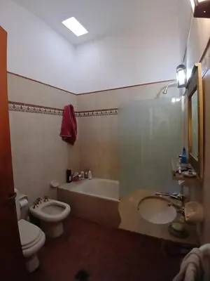 a bathroom with a toilet and a tub and a sink at Casa Corna in Río Cuarto