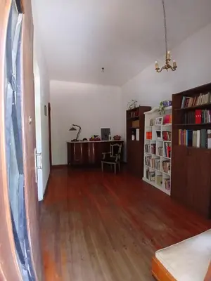 an empty living room with wooden floors and a book shelf at Casa Corna in Río Cuarto