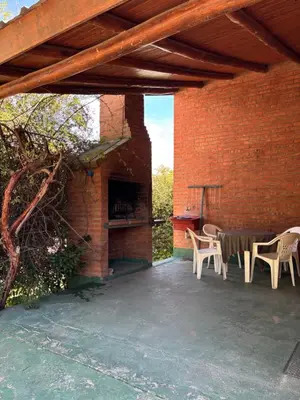 a patio with a table and chairs and a brick wall at Complejo Alto Paraiso in Villa Cura Brochero