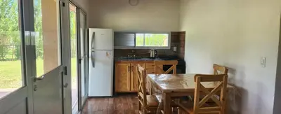 a kitchen with a table and a white refrigerator at Aire de montaña in Quebrada de los Pozos