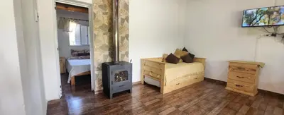 a room with a fireplace and a bedroom with a bed at Aire de montaña in Quebrada de los Pozos