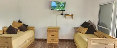 a room with two beds and a tv on the wall at Aire de montaña in Quebrada de los Pozos