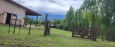 a group of wooden gates in the grass near a building at Aire de montaña in Quebrada de los Pozos