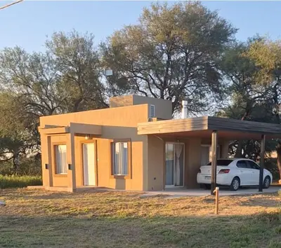 a small house with a car parked in front of it at Casa en Merlo in Cañada La Negra