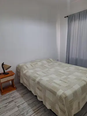 a bedroom with a bed and a table and a window at Casa en Merlo in Cañada La Negra