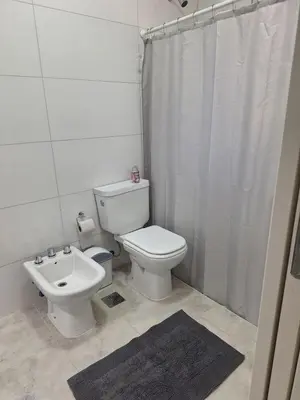 a white bathroom with a toilet and a sink at Casa en Merlo in Cañada La Negra