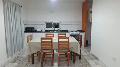 a kitchen with a table and chairs and a kitchen with a stove at Casa en Merlo in Cañada La Negra