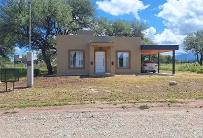 a small house with a car parked in front of it at Casa en Merlo in Cañada La Negra