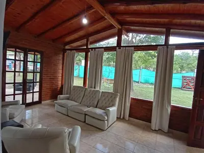 a living room with a couch and some windows at Complejo LA ADELAIDA in Mina Clavero