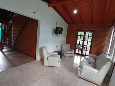 a living room with two chairs and a couch at Complejo LA ADELAIDA in Mina Clavero