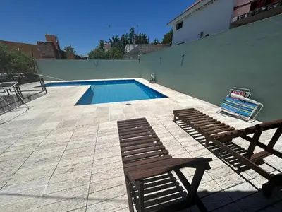 a swimming pool with a bench and a chair at Cabaña con pileta en Villa Carlos Paz in Villa Carlos Paz