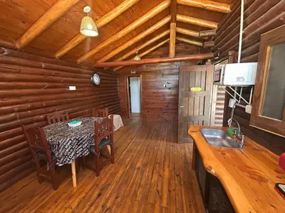 a dining room with a table in a log cabin at Cabaña con pileta en Villa Carlos Paz in Villa Carlos Paz