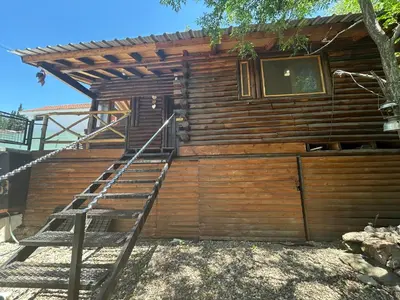 a wooden cabin with a staircase leading up to it at Cabaña con pileta en Villa Carlos Paz in Villa Carlos Paz