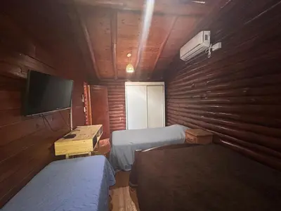 a small room with two beds and a television at Cabaña con pileta en Villa Carlos Paz in Villa Carlos Paz