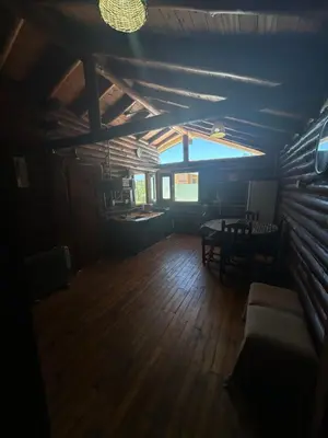 an attic room with a couch and a table at Cabaña con pileta en Villa Carlos Paz in Villa Carlos Paz
