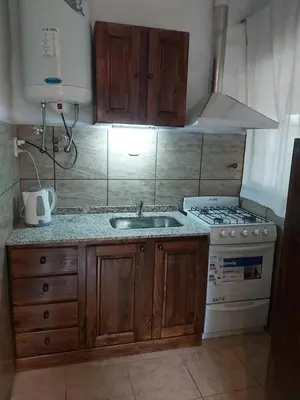 a kitchen with a sink and a stove at Cabaña - casa - chalet con pileta a minutos de Villa Carlos Paz para 8 personas in San Roque