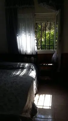a bedroom with a bed and a window with sunlight at Cabaña - casa - chalet con pileta a minutos de Villa Carlos Paz para 8 personas in San Roque