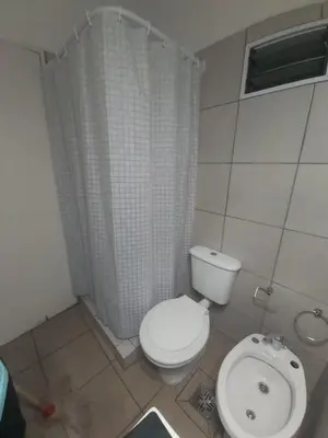 a bathroom with a toilet and a shower curtain at Cabaña - casa - chalet con pileta a minutos de Villa Carlos Paz para 8 personas in San Roque