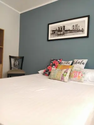 a bed with white sheets and pillows on it at Departamento de los Cuadros in Villa Carlos Paz