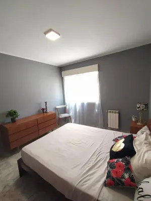 a bedroom with a large bed and a window at Departamento de los Cuadros in Villa Carlos Paz