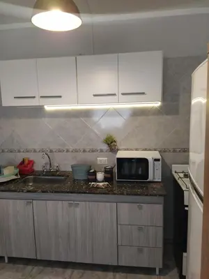 a kitchen with a sink and a microwave at Departamento de los Cuadros in Villa Carlos Paz