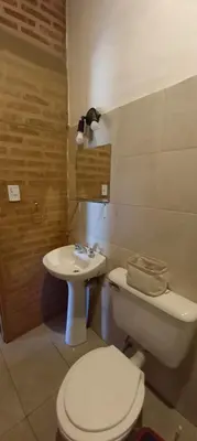 a bathroom with a toilet and a sink at Brisas de Montaña in Mina Clavero