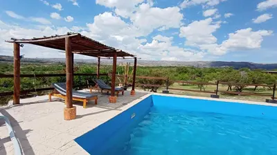 a swimming pool with a gazebo and a swimming poolvisor at Brisas de Montaña in Mina Clavero