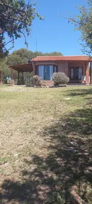 a house with a large yard in front of it at Brisas de Montaña in Mina Clavero