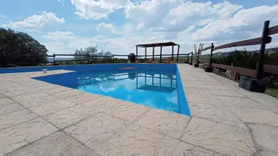 a blue swimming pool with a wooden fence around it at Brisas de Montaña in Mina Clavero