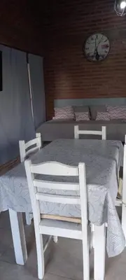 a white table and chairs in a room with a clock at Brisas de Montaña in Mina Clavero