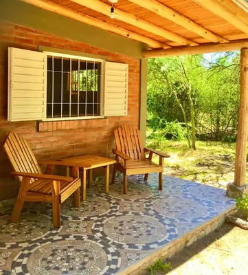 two chairs and a table on a patio at Hogar Serrano in Villa de Las Rosas