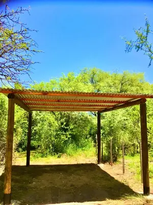 a pavilion with a red roof in a field at Hogar Serrano in Villa de Las Rosas