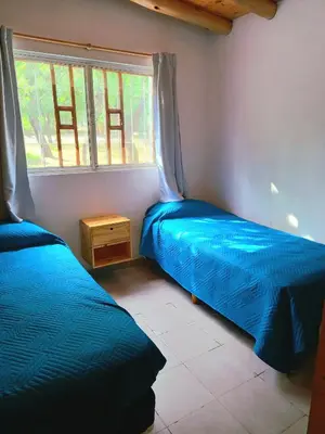 two beds in a room with a window at Hogar Serrano in Villa de Las Rosas
