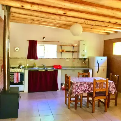 a kitchen with a table and chairs and a refrigerator at Hogar Serrano in Villa de Las Rosas
