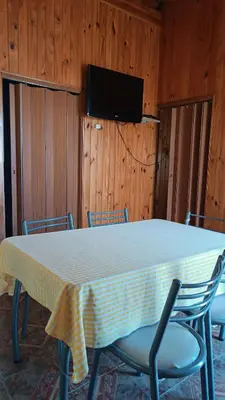 a room with a table with chairs and a television at Depto en planta alta in Villa Carlos Paz