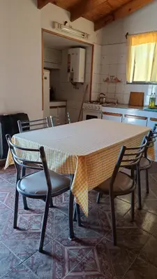 a kitchen with a table with chairs and a table cloth at Depto en planta alta in Villa Carlos Paz