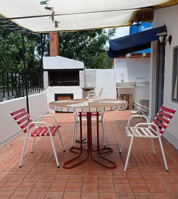 a table and chairs on a patio with an umbrella at Depto en planta alta in Villa Carlos Paz